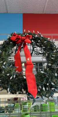 Couronne de Noël ornée de guirlandes lumineuses et d'un ruban rouge